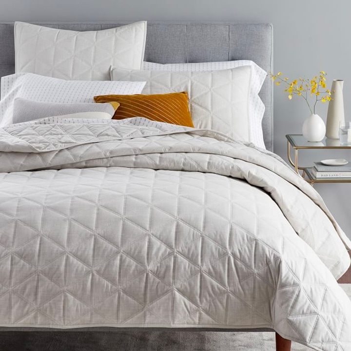 Gray sateen quilt on made bed
