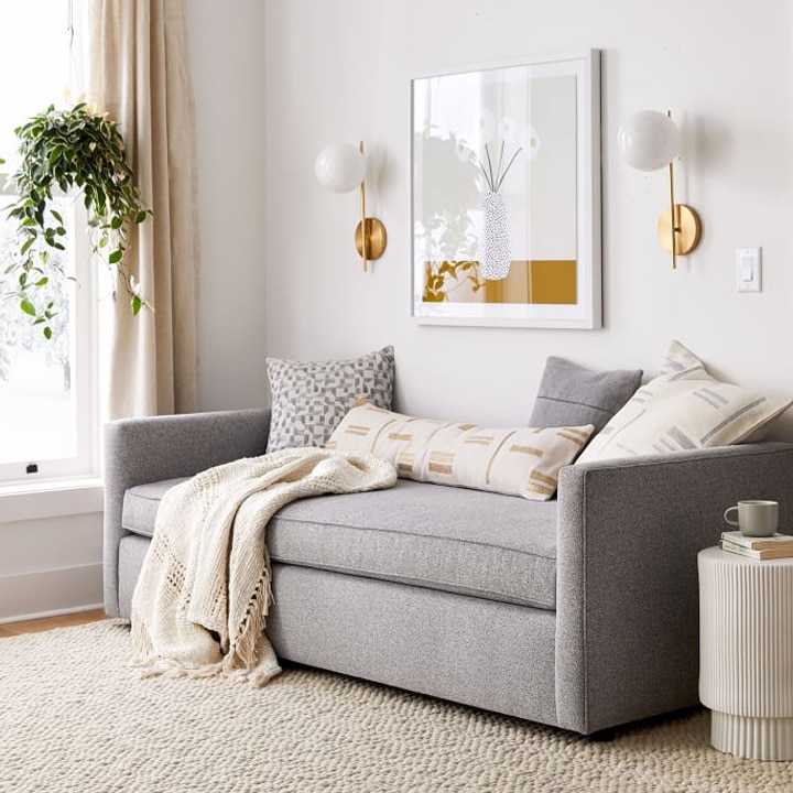 Gray daybed with cream pillows and blanket