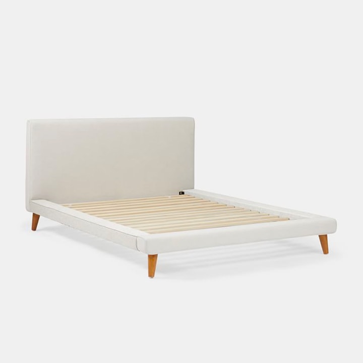 Tan upholstered platform bed without mattress