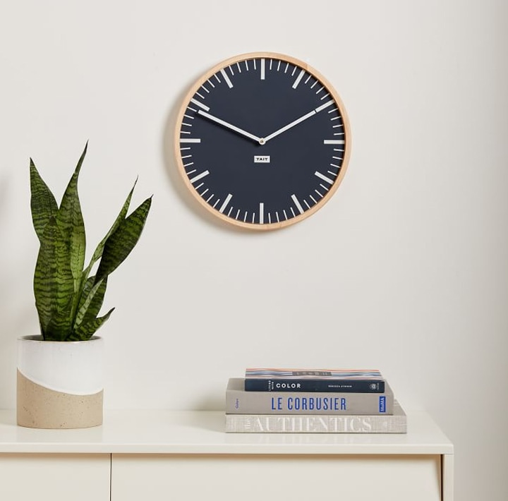 Wall clock with plant and books