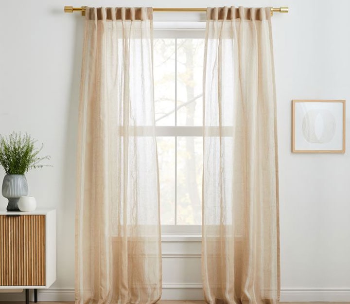 Natural sheer curtain covering window