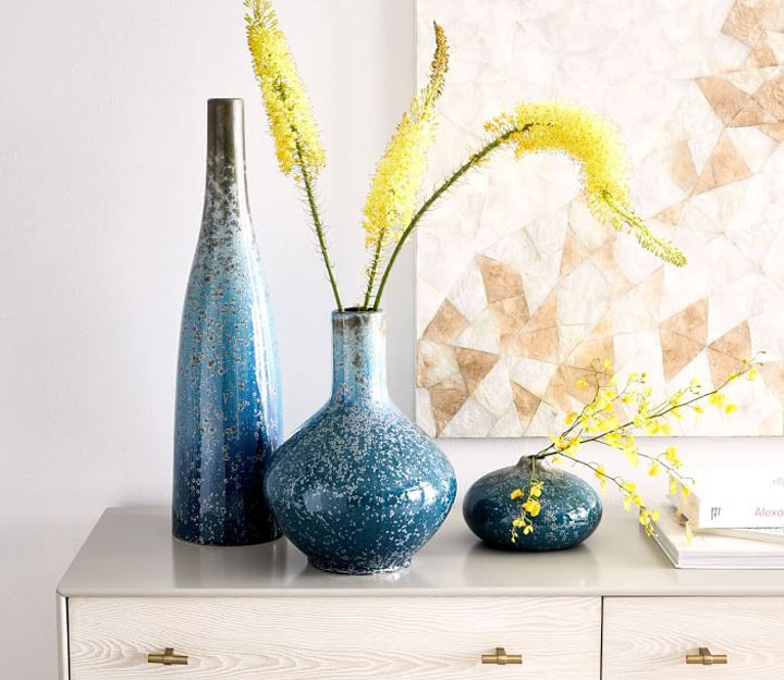 Ceramic blue vases filled with faux yellow botanicals