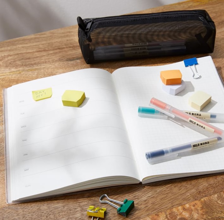 Notebook with colorful pens, clips and erasers