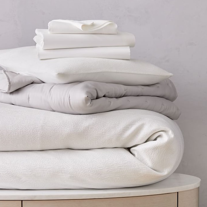 stack of white and gray TENCEL™ folded sheets