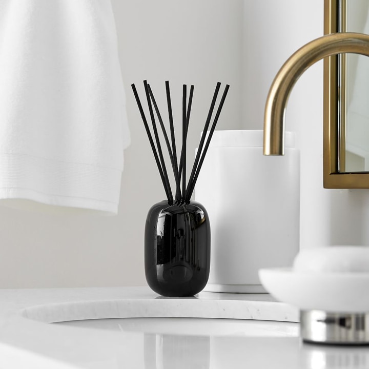 Black essential oil diffuser on bathroom vanity.