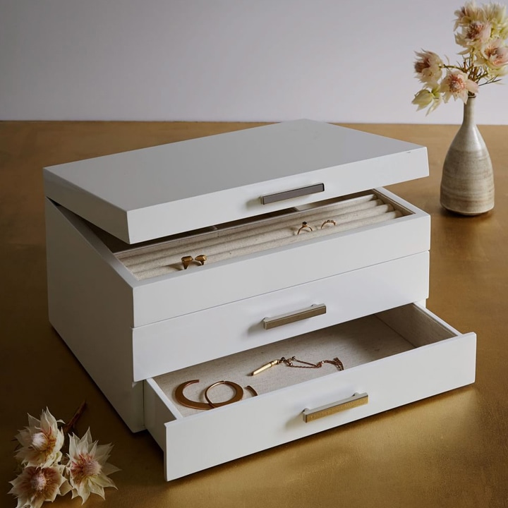 White and gold jewelry box with three drawers.