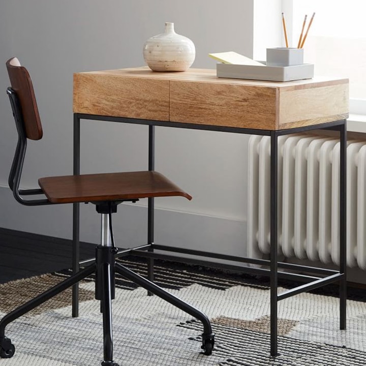Industrial desk with brown chair and rug.
