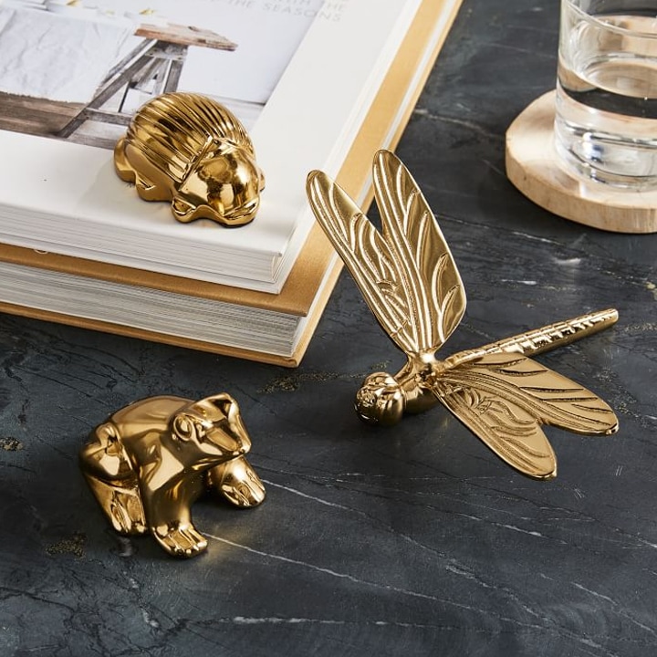Gold nature paperweights with books on desk.