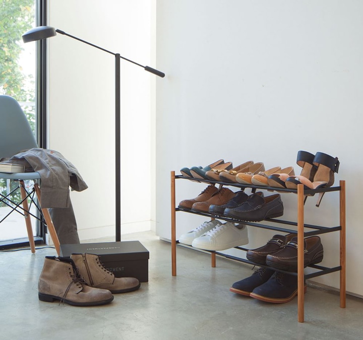 Black and wood shoe rack with several shoes.