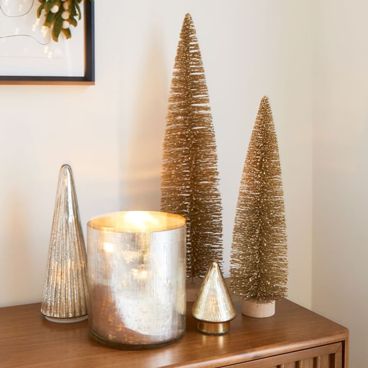 gold tabletop christmas trees on wooden cabinet