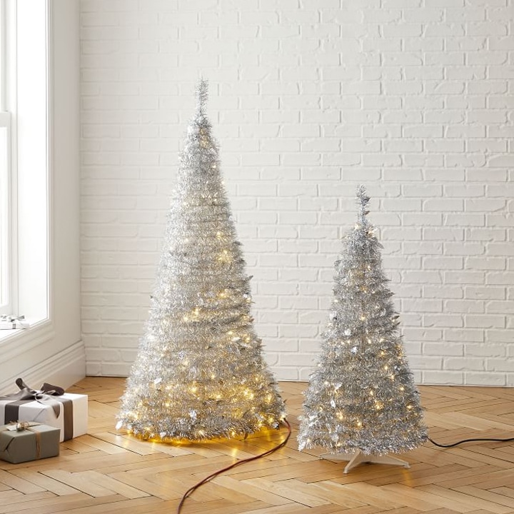 two white tinsel christmas trees with lights