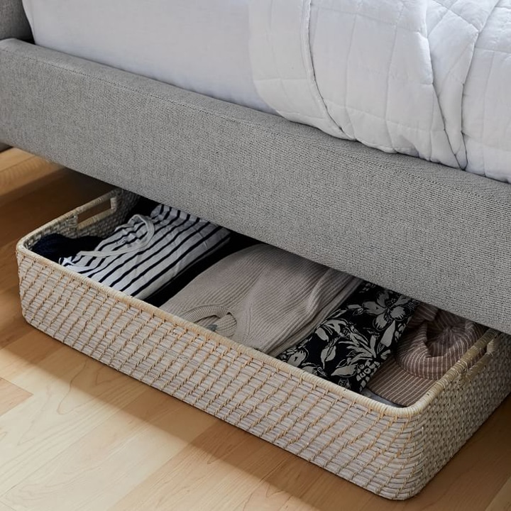 Under bed storage basket with clothes.