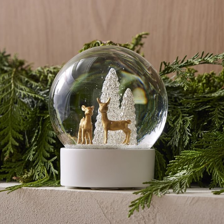 snow globe with white trees and reindeer