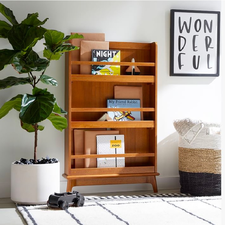 Modern narrow bookcase next to plant and basket