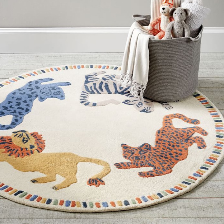 Round rug with animals on it in a nursery with a basket of toys