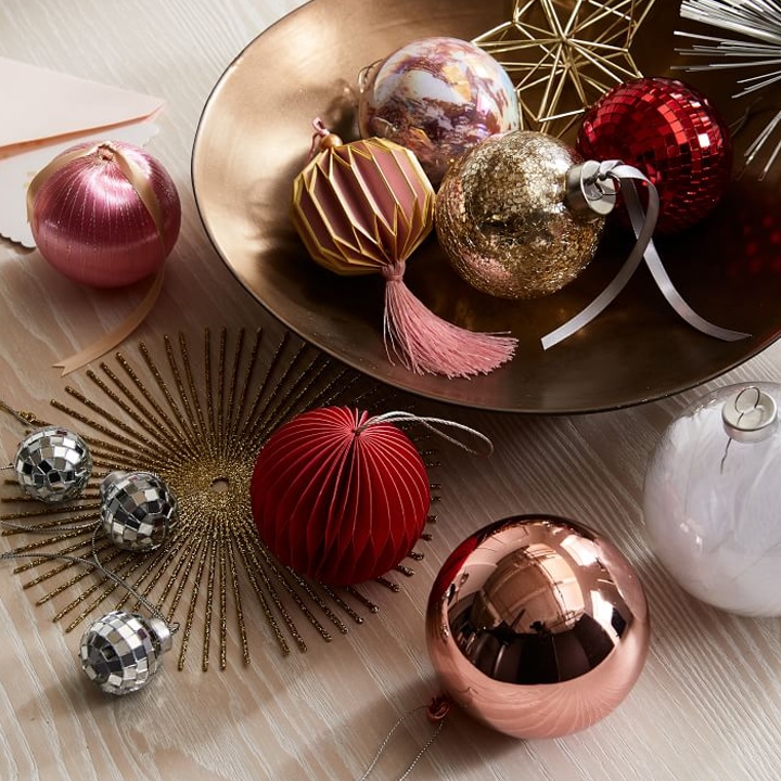 bowl of red, gold, pink, and silver shiny and sparkly christmas ornaments
