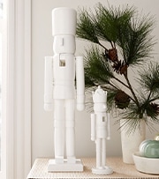 white nutcrackers on table with pine branches
