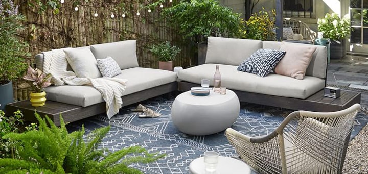 Backyard patio with outdoor sofas and lounge chair.