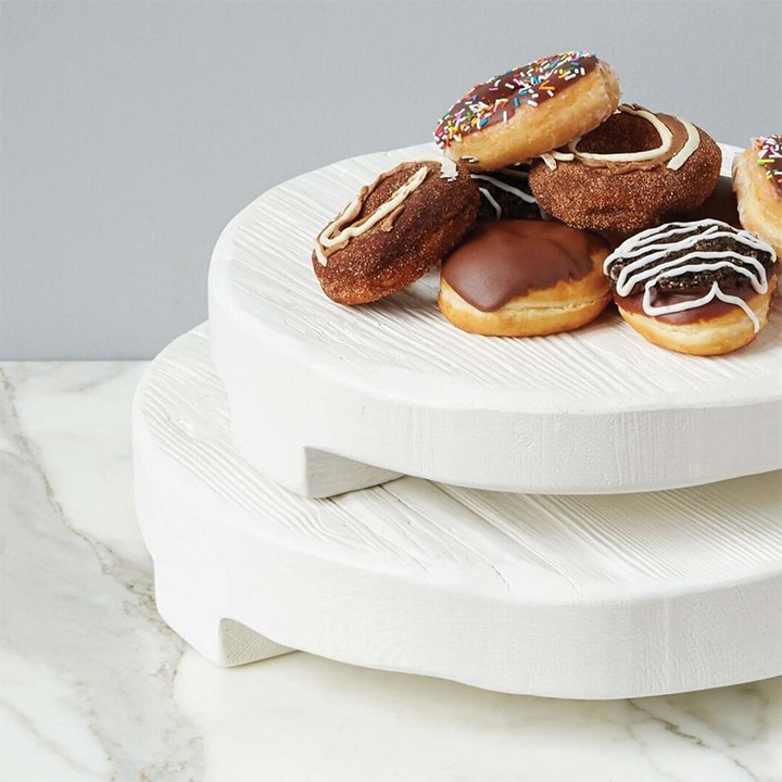 Sweets stacked on white wooden round trivets.