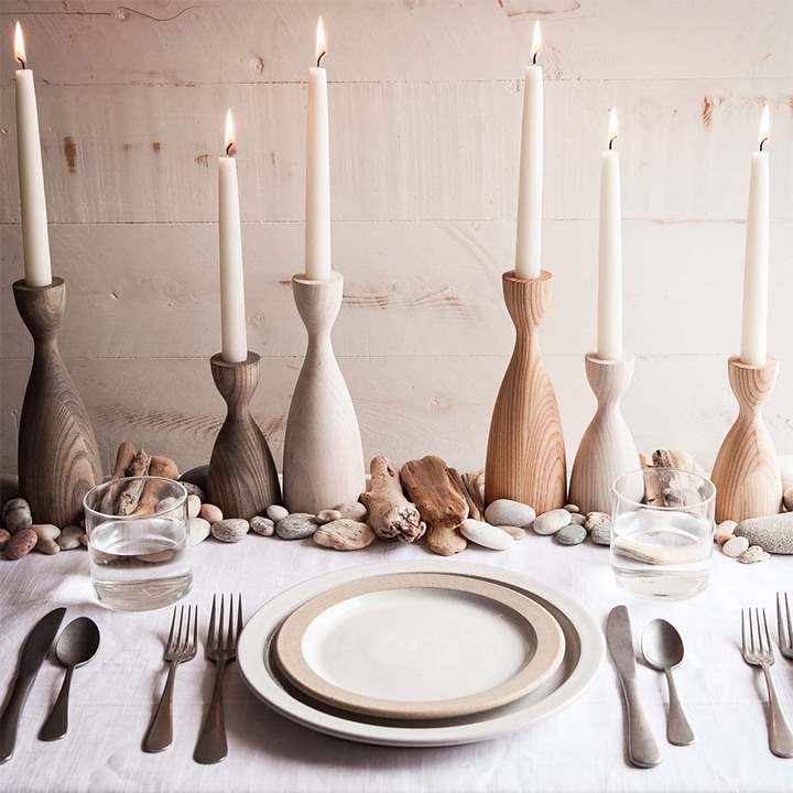 Wooden candlestick holders on placed table. 