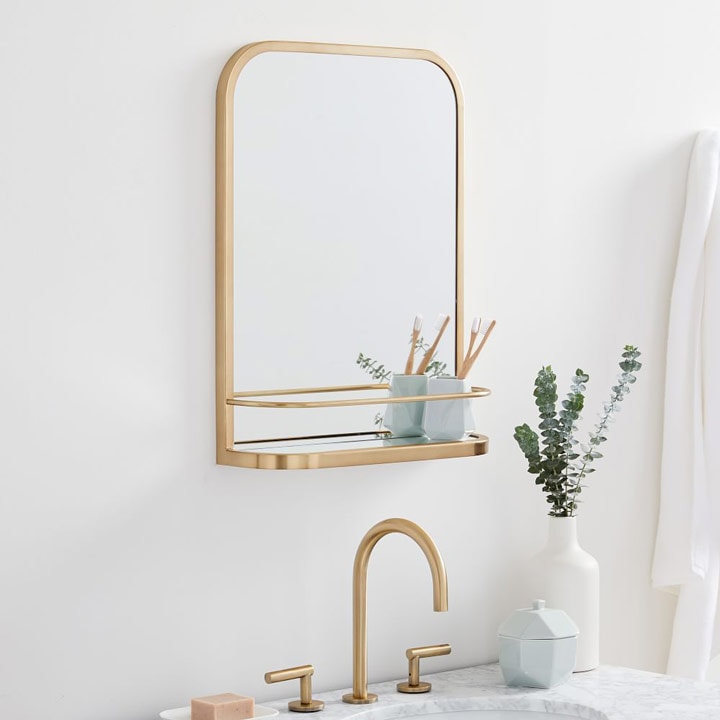 Mirror with shelf above bathroom vanity.