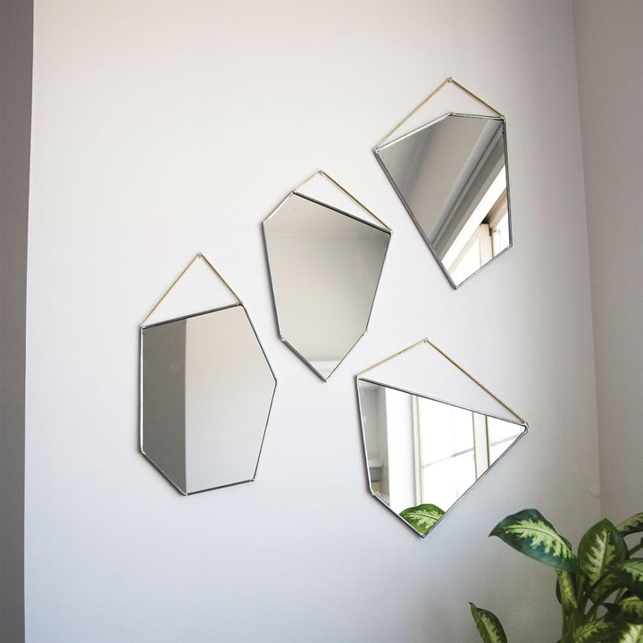 Collection of modern angular mirrors hanging on wall.