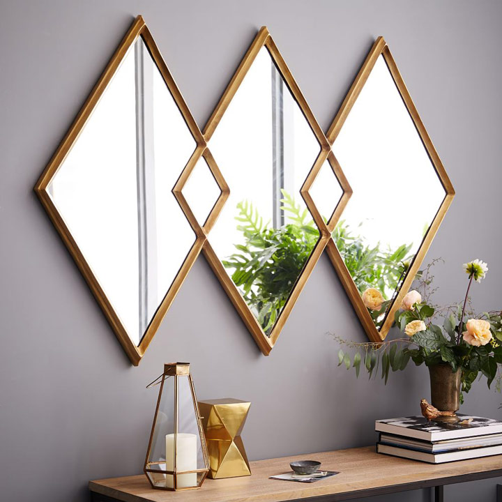 Overlapping diamond mirrors above table with books.