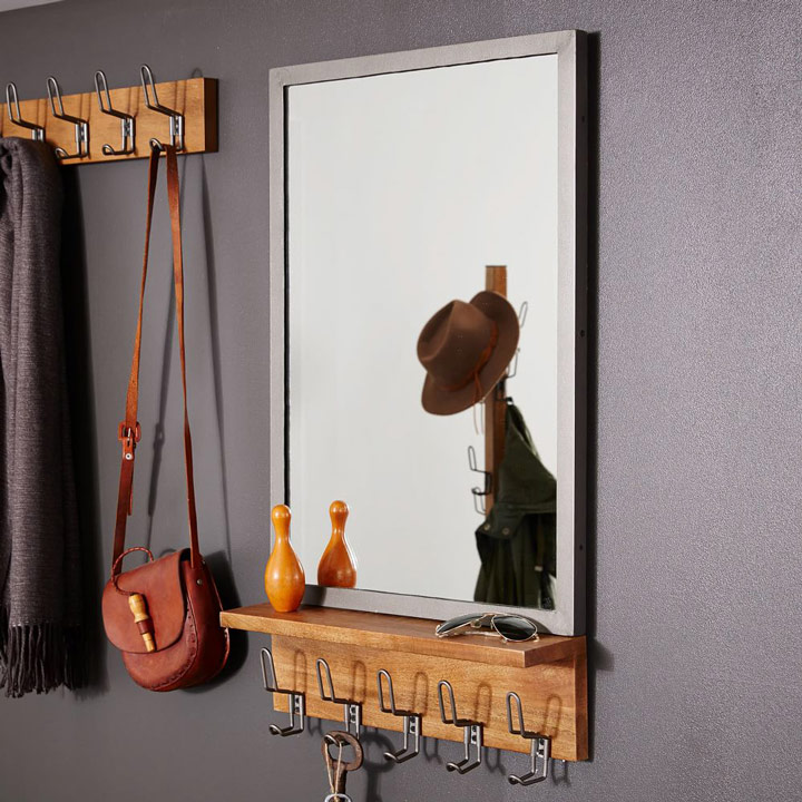 Metal frame mirror with shelf and coat hooks.