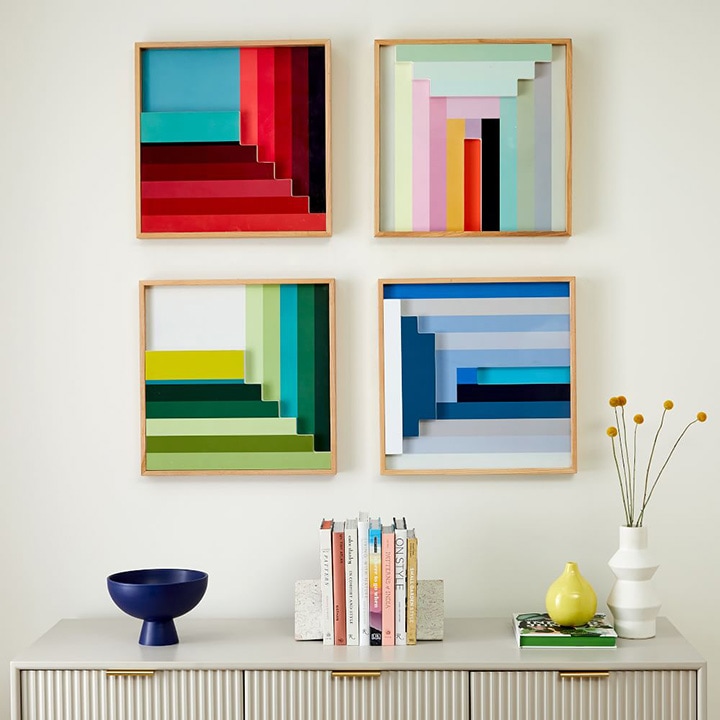 Four picture frames on a wall in various colors and rectangular patterns