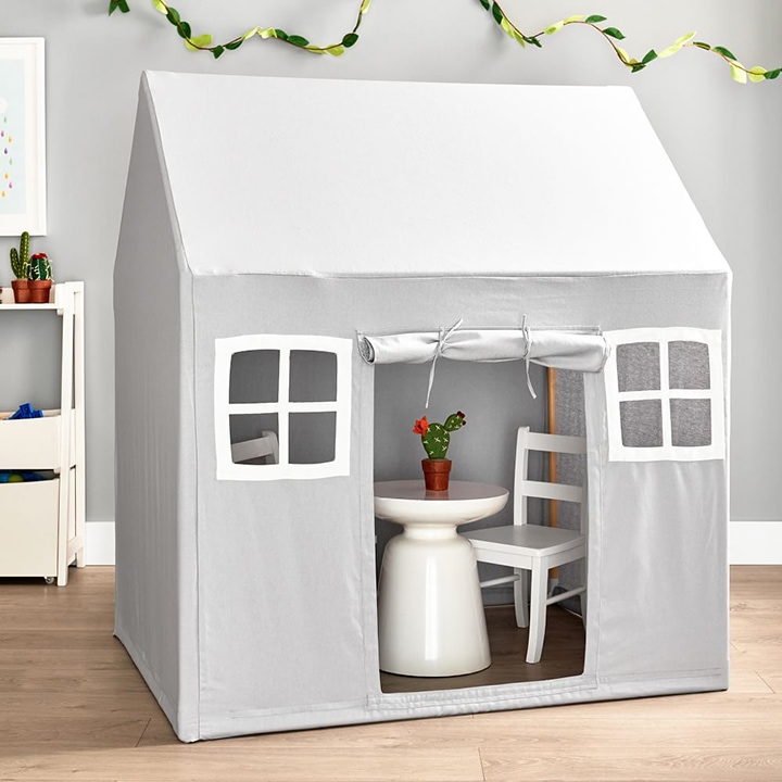 Gray playhouse with windows and a white dining set inside