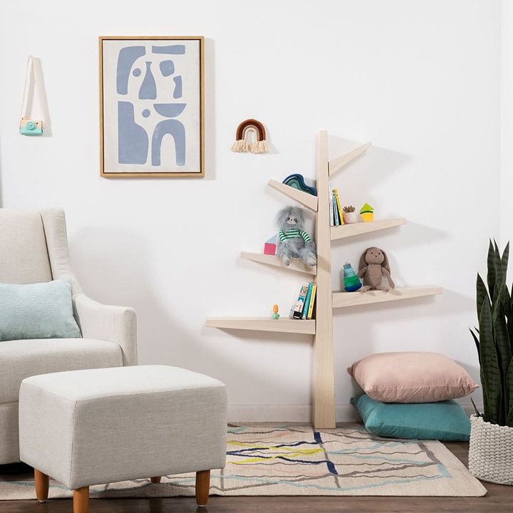 Living room with couch, ottoman, toy shelves, pillows and other decor
