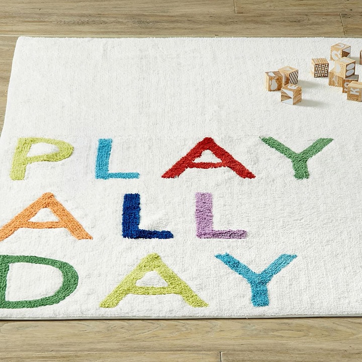 White rug with written phrase in multicolor letters