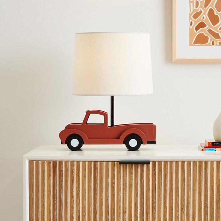 White lampshade with a red truck as its base