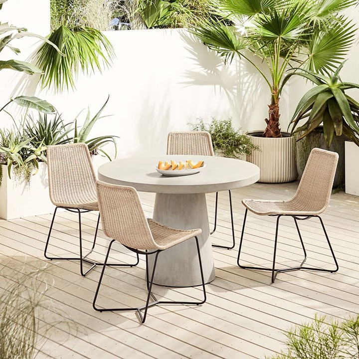 Outdoor bistro table and four wicker dining chairs. 