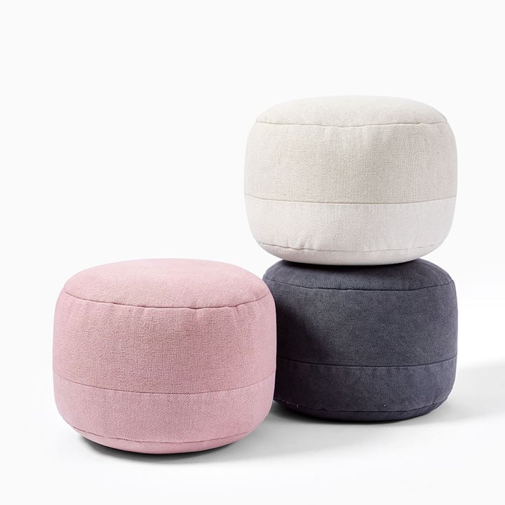 Pink, white and blue pouf chair on floor.