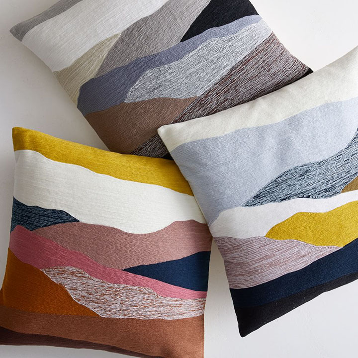 Three decorative pillows with multi-colored design