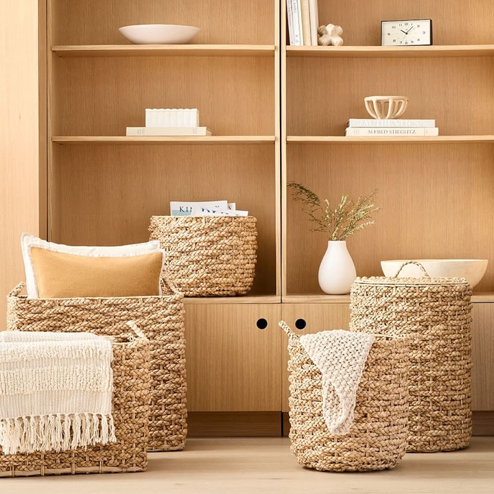 Wood wall organizer with four handwoven baskets.