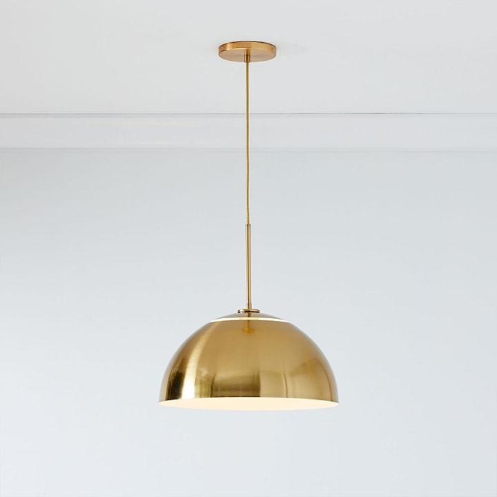 Oversize antique brass metal pendant with brass cord.