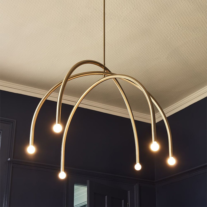 Brass arc chandelier hanging from the ceiling.