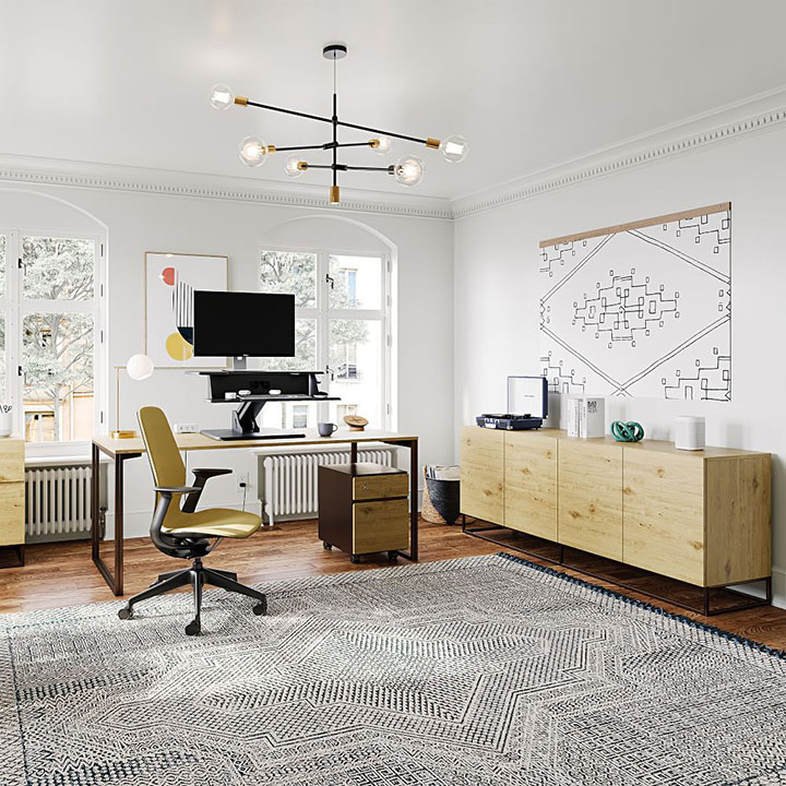 Bulb light fixture above office desk and chair with black and gray area rug and light wood media table. 