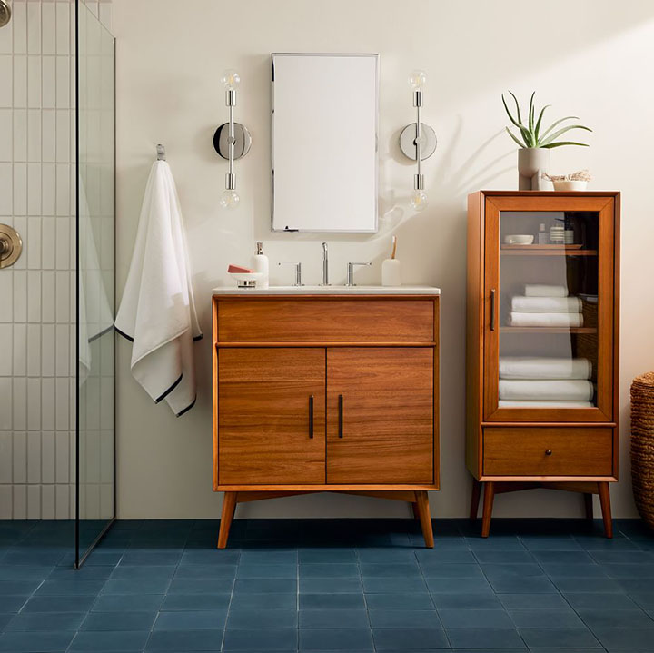 Blue floor tile with dark wood bathroom vanity and storage unit. 