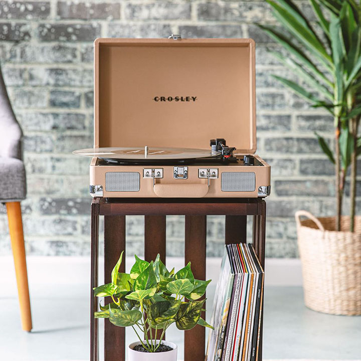 Blush pink record player in music room with record collection and assorted trees. 