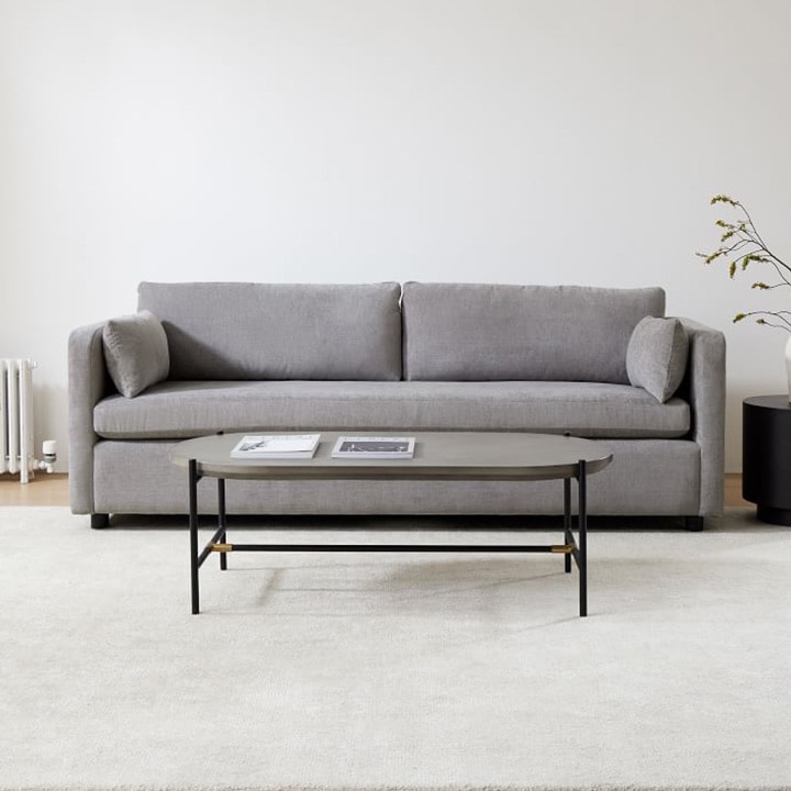 Deep gray loveseat with shades of gray paint and area rug. 