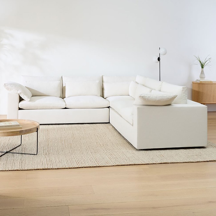 Cream sofa, beige area rug and wood coffee table. 