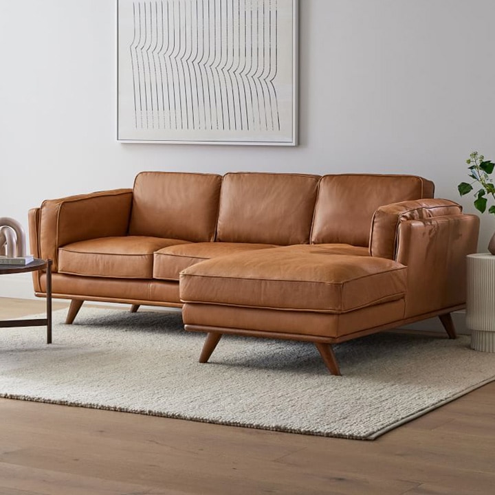 Brown sofa with a sand-colored area rug.