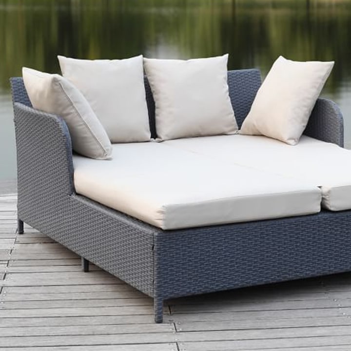 Rattan outdoor daybed in front of lake