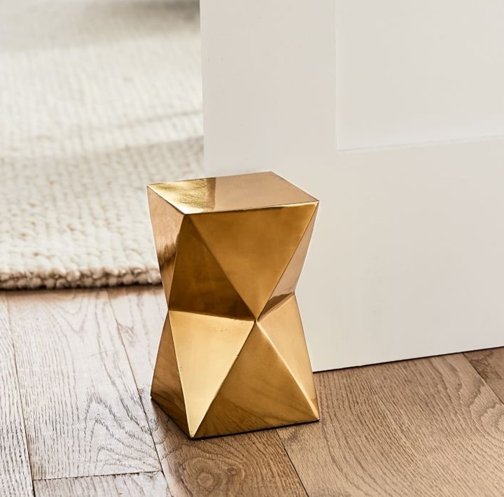Gold geometric doorstop on hardwood floor