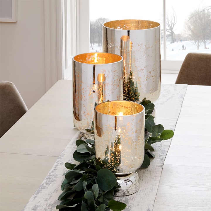 Silver candle pedestals shimmering on table.