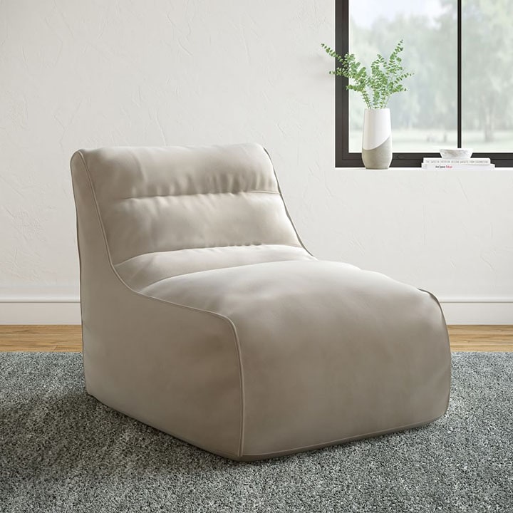 Neutral bean bag chair next to window.