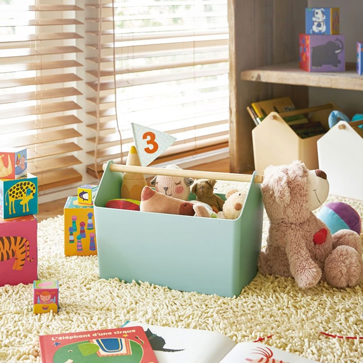 Teal caddy with toys in playroom.